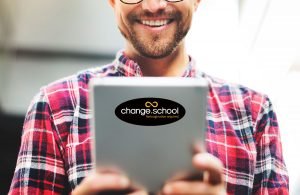 Man holding tablet with Change School sticker